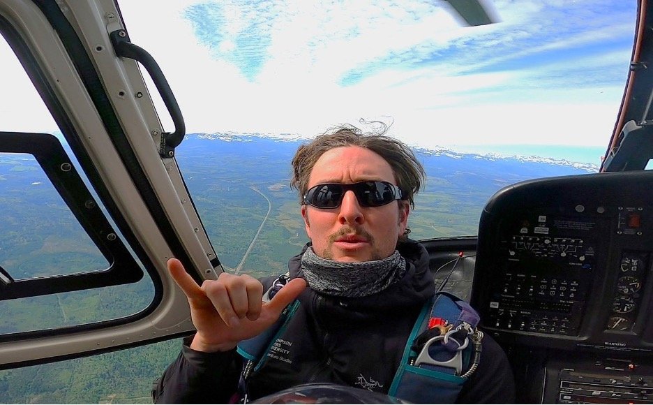 Man looking at camera while inside a helicopter