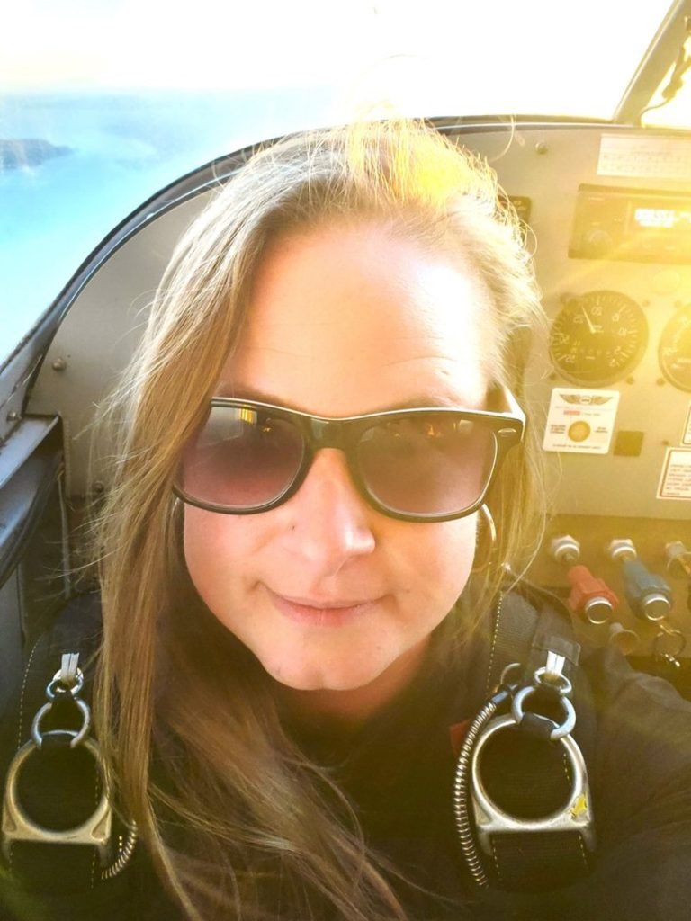 Woman smiling at camera inside a small plane