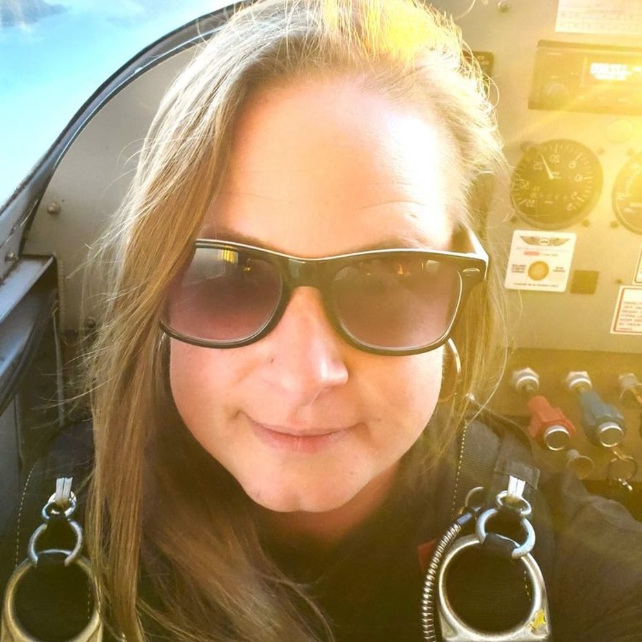 Woman smiling at camera inside a small plane